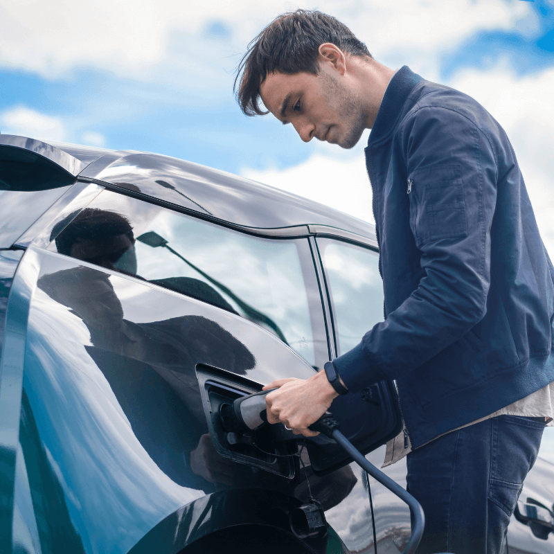 persona mentre ricarica dopo noleggio lungo termine auto elettriche